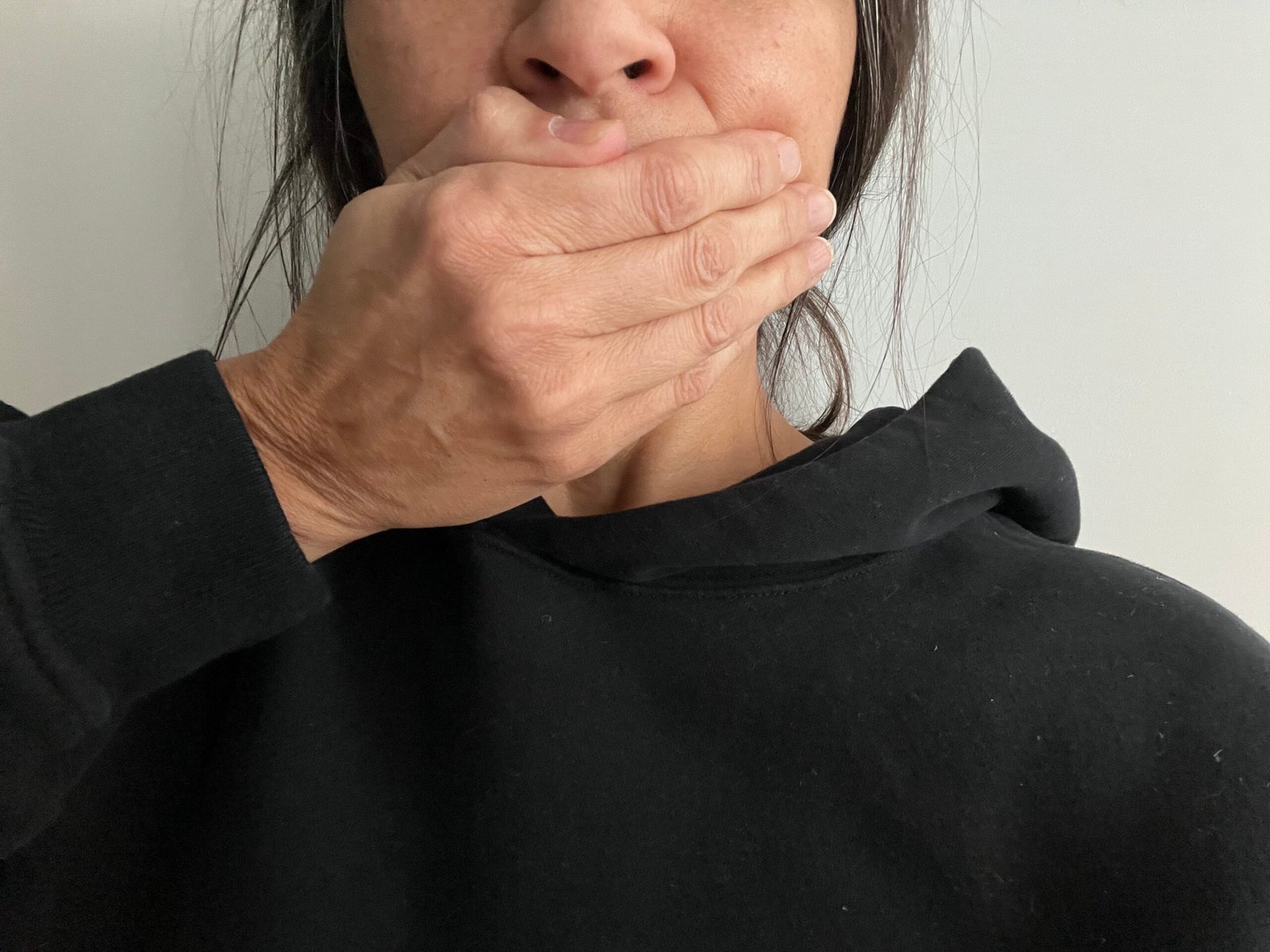 Female covering her mouth with her hand.