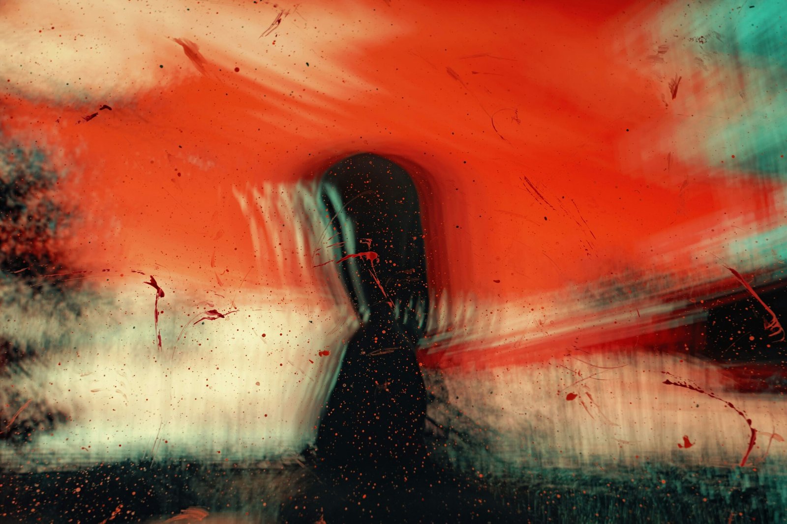 An abstract image of bright colors of red, black, green, and white, with what looks like a person's figure in the center.