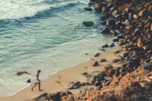 Image of a surfer walking out of the ocean to the shore